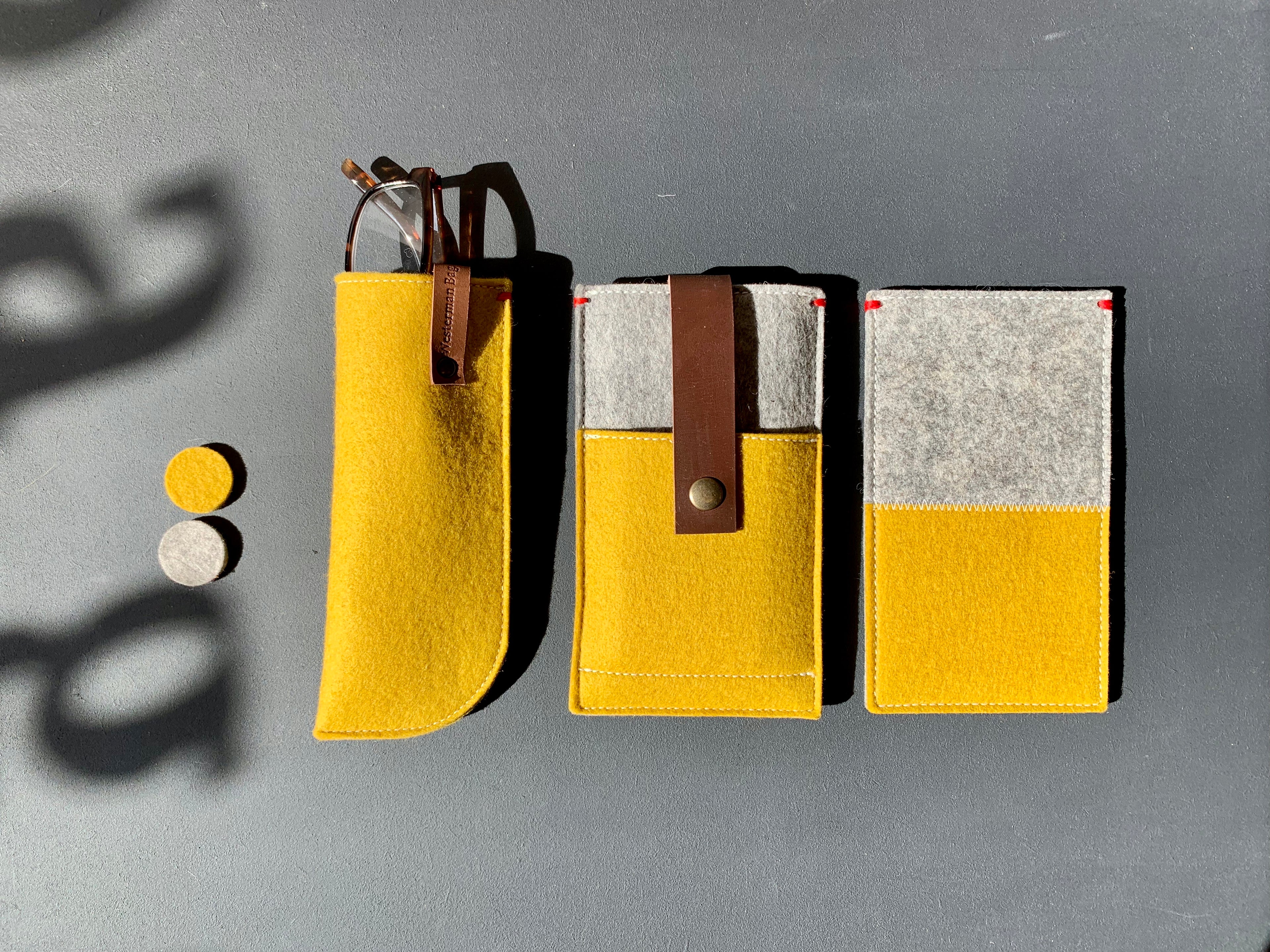 Handgemaakte vilten hoezen en tassen van wolvilt in geel en grijs met leren sluiting